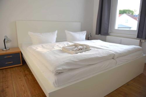 een wit bed met een hoed erop bij Villa Meeresgruss FeWo 9 in Ostseebad Sellin