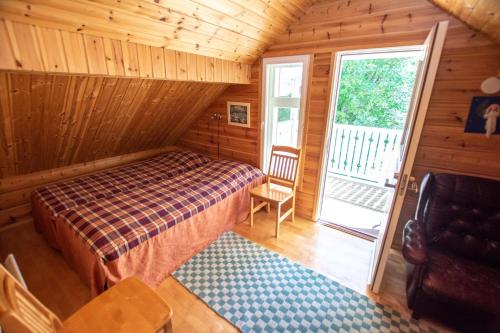 Dormitorio con cama y ventana en una cabaña en Villa Rentola, en Pääjärvi
