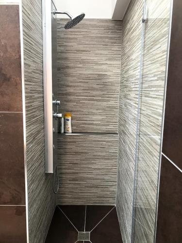 a bathroom with a shower with a glass door at La Conca in San Giovanni la Punta