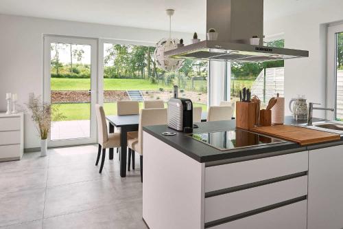 a kitchen with a counter and a table with chairs at Meeresvilla Lobbe in Lobbe