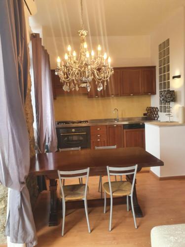 een keuken met een tafel en stoelen en een kroonluchter bij Sciala' 2 in Taormina