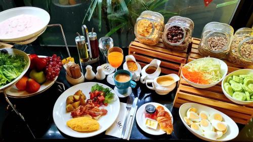a table topped with plates of food and bowls of food at Alt Hotel Nana by UHG in Bangkok