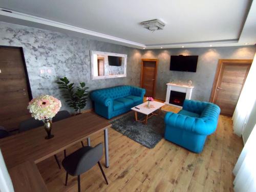 a living room with two blue couches and a fireplace at Canti apartments in Novi Sad