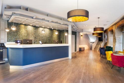 a lobby with a blue counter and chairs at B&B HOTEL Madrid Centro Plaza Mayor in Madrid