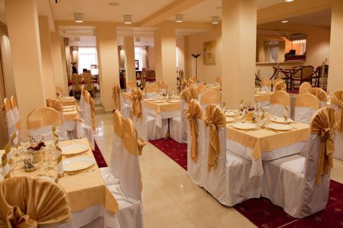 クルジュ・ナポカにあるホテル アリーの白いテーブルと椅子と弓の宴会場