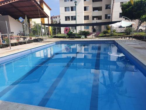 a large blue swimming pool in front of a building at La mejor ubicación. A unas cuadras del centro in Santa Cruz Huatulco