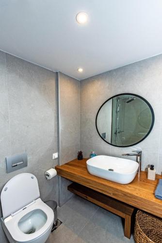 a bathroom with a sink and a toilet and a mirror at Memoria in Gerani
