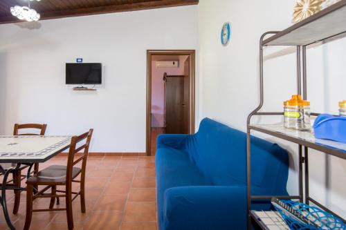 ein Wohnzimmer mit einem blauen Sofa und einem Tisch in der Unterkunft Villa Sajonara Elvira in Fontane Bianche