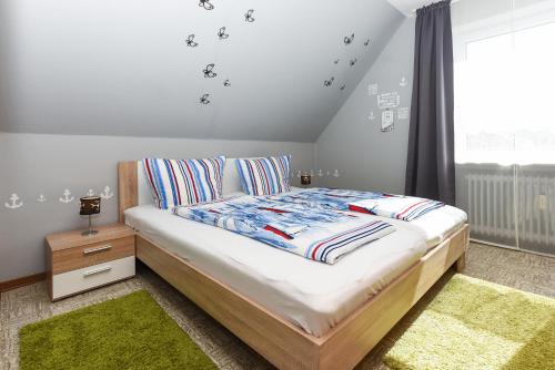 een slaapkamer met een bed en een raam bij Ferienwohnungen Wind & Meer in Neuharlingersiel