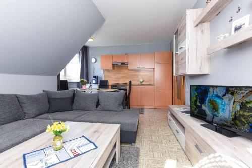 een woonkamer met een bank en een tv bij Ferienwohnungen Wind & Meer in Neuharlingersiel