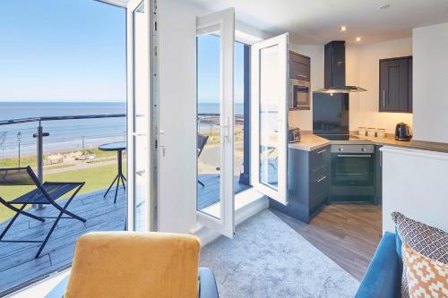 a kitchen with a balcony with a view of the ocean at Host & Stay - The Waves in Whitby