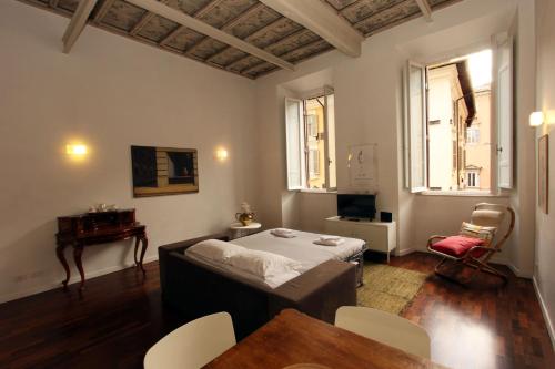 ローマにあるOttoboni Flatsのベッド、テーブル、椅子が備わる客室です。