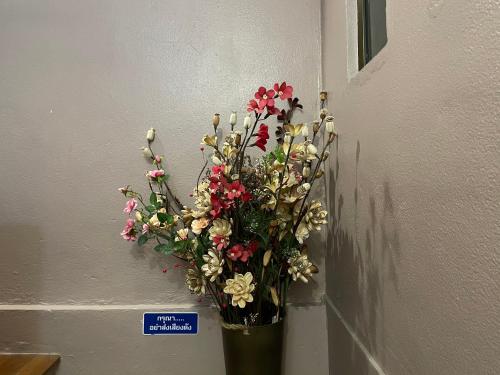 a vase of flowers is hanging on a wall at Nawaporn Place in Phuket Town