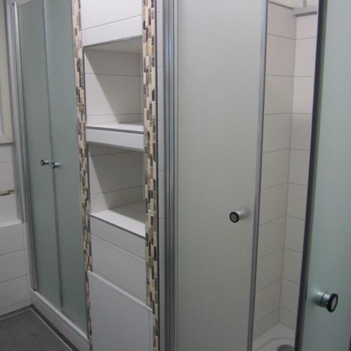 a closet with a glass door and shelves at Schlaffass-Camping Gutshof Donauried in Günzburg
