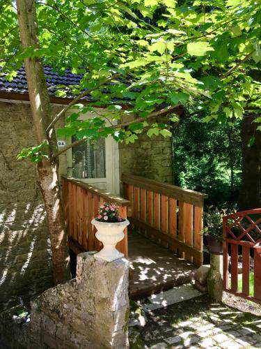 a porch of a house with a flower pot on it at Domaine Du Moulin Vallée Heureuse in Poligny