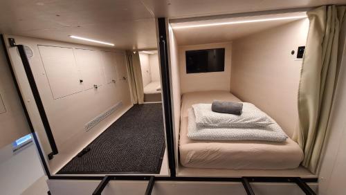 Cabin HOSTEL في ليوبليانا: غرفة صغيرة بها سرير ومرآة