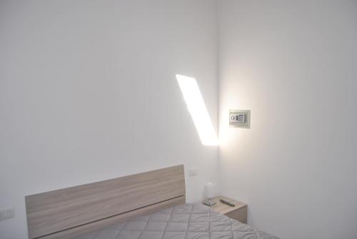 a bedroom with a bed and a light on the wall at LE DIMORE DI DAMAROPE' in Agrigento