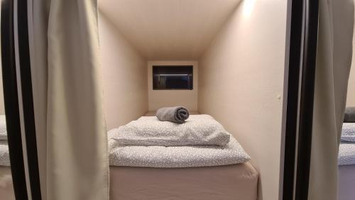 Cabin HOSTEL في ليوبليانا: غرفة صغيرة مع مناشف تجلس على كرسي