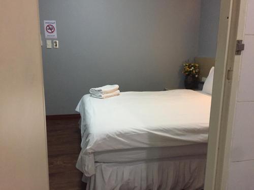 a bedroom with a white bed with towels on it at Nawaporn Place in Phuket Town