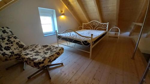 een kamer met een bed, een stoel en een raam bij Ferienwohnung Sonnenhang in Rüdenau