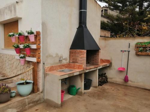 a outdoor kitchen with a brick oven with potted plants at Casa Pepe de L´ullat in Deltebre