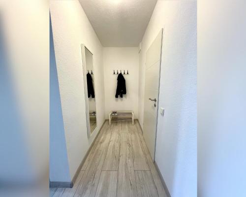 - un couloir avec des murs blancs et du parquet dans l'établissement Ferienwohnung Apothekerhaus, à Bad Sassendorf