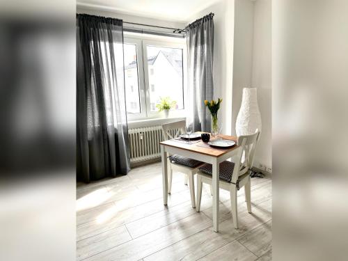a dining room with a table and chairs and a window at Ferienwohnung Apothekerhaus in Bad Sassendorf