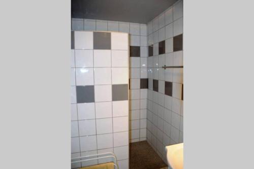 La salle de bains est pourvue de murs carrelés blancs et d'une douche. dans l'établissement T3 familial avec accès direct à la plage., à Banyuls-sur-Mer