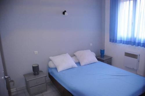 une chambre avec un lit avec deux oreillers blancs dans l'établissement T3 familial avec accès direct à la plage., à Banyuls-sur-Mer