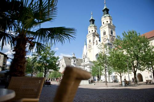 a building with two towers with a palm tree in front at Berghotel Schlemmer in Bressanone