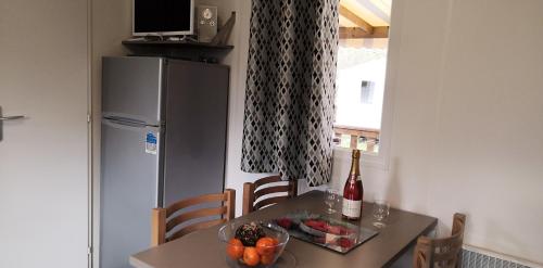 a small kitchen with a table and a refrigerator at Bungalow charmant Onzain + Piscine in Onzain