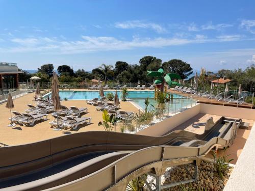 un complexe avec une piscine avec des chaises longues dans l'établissement Mobil home Chalet 35 m2 camping l ile d or Saint-raphael, à Saint-Raphaël