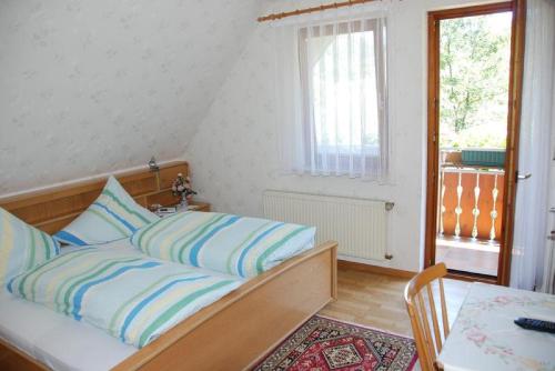 a bedroom with a bed and a table and a window at Pension Schneider in Freiamt