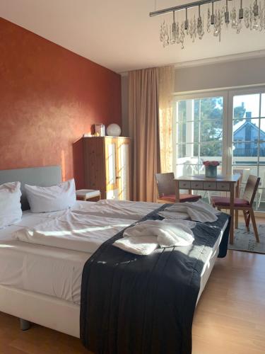 a bedroom with a large bed and a dining room at ART-hüs in Westerland