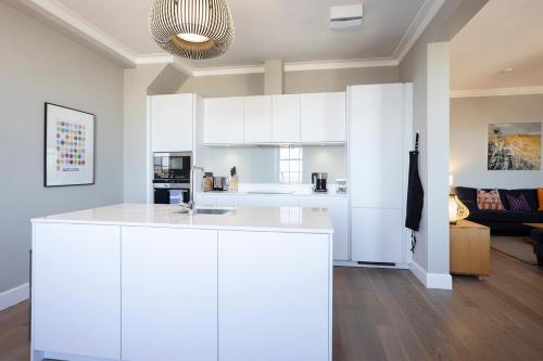 a white kitchen with a white island in a room at JOIVY Splendid Apartment in New Town in Edinburgh