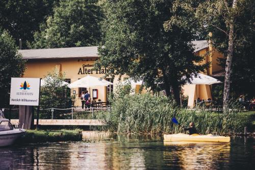 a building next to a river with a boat in it at Pension Alter Hafen in Zehdenick