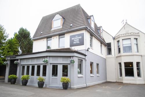 a white building with potted plants in front of it at Richmond Park Hotel in Boʼness