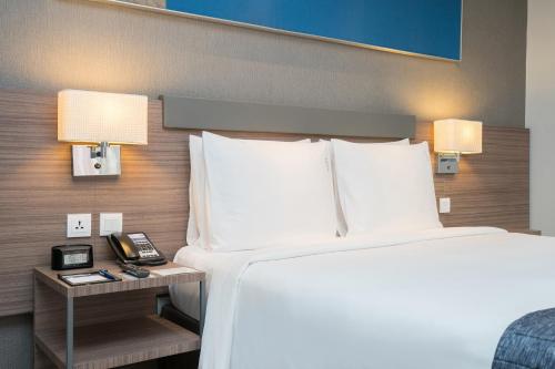 a hotel room with a bed and a telephone at Holiday Inn Express Bangkok Sathorn by IHG in Bangkok