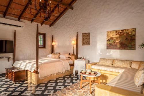 a bedroom with a bed and a couch at Amrapali-House of Grace in Bambolim