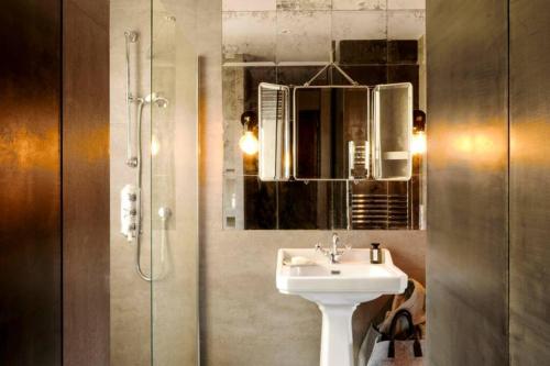 a bathroom with a sink and a shower with a mirror at Amazing Design Flat - Le Marais - with view in Paris