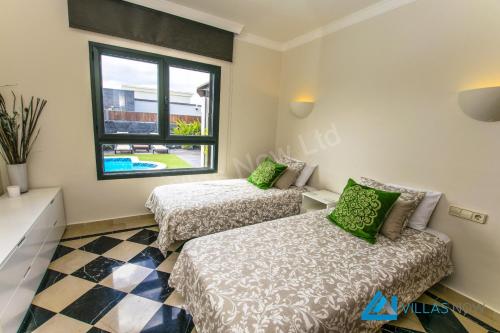 1 Schlafzimmer mit 2 Betten und einem Fenster in der Unterkunft Casa Braeside - LH204 By Villas Now Ltd in Playa Blanca