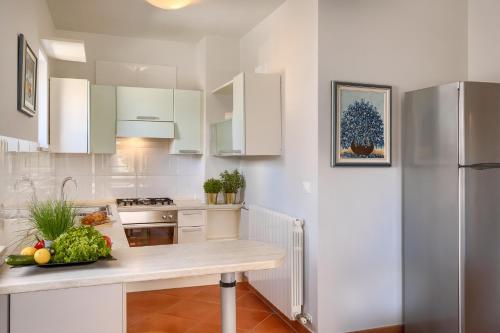 a kitchen with white cabinets and a counter with vegetables on it at Belvedere Holidays Villas in Novigrad Istria