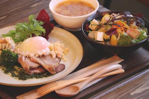 a table with two plates of food and a bowl of soup at LINNAS Kanazawa in Kanazawa