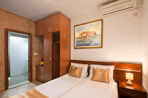 a bedroom with a large white bed in a room at Apartmani Salus in Budva
