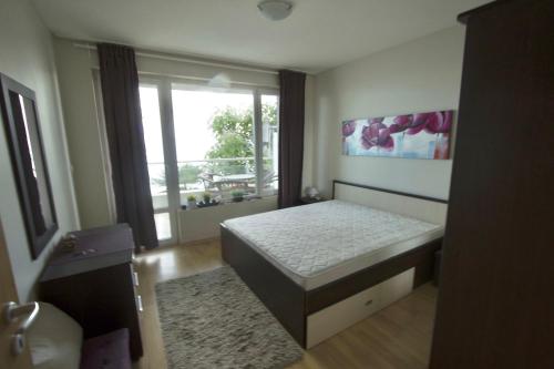 a bedroom with a bed and a large window at Apartmán Alex beach s nádherným panoramatickým výhledem na moře in Sveti Vlas