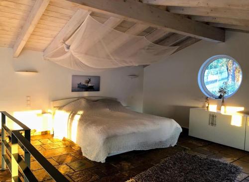 a bedroom with a bed in a room with a window at Natur-Steinhaus mit Meerblick: hell, ruhig, exklusiv, strandnah in Liapades