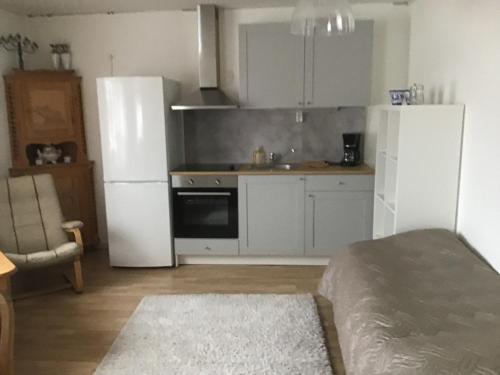 a kitchen with white cabinets and a white refrigerator at Västerdala Onwest in Äppelbo