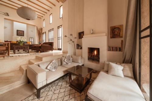 a living room with a couch and a fireplace at Tagadert Lodge in Oumnas