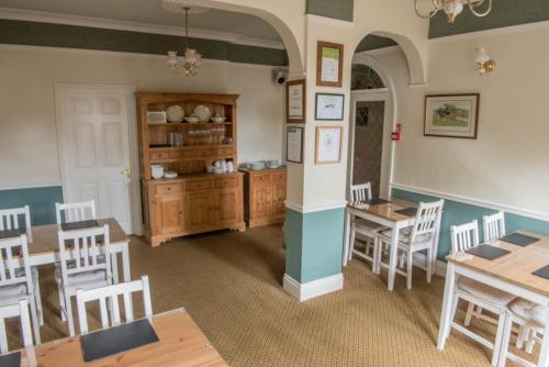 a dining room with wooden tables and chairs at Toothbrush Rooms at Lattice Lodge - Self Catering in Ipswich