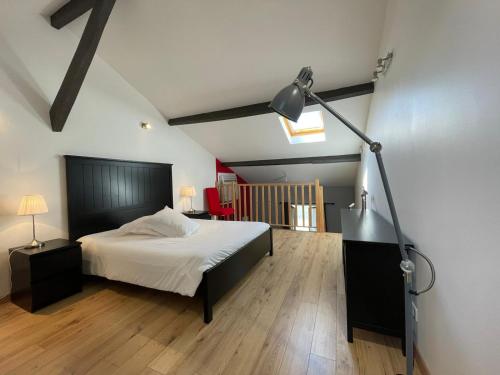 サン・テミリオンにあるLes Logis des Vignobles Sainte Emilion en Duplex n 1 avec terrasseのベッドルーム1室(ベッド1台、ランプ付きデスク付)